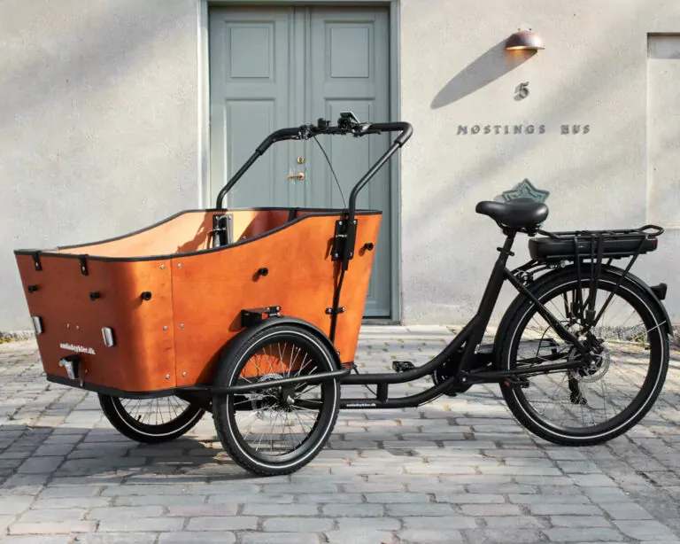 Black electric tricycle with orange cargo area over twin front wheels