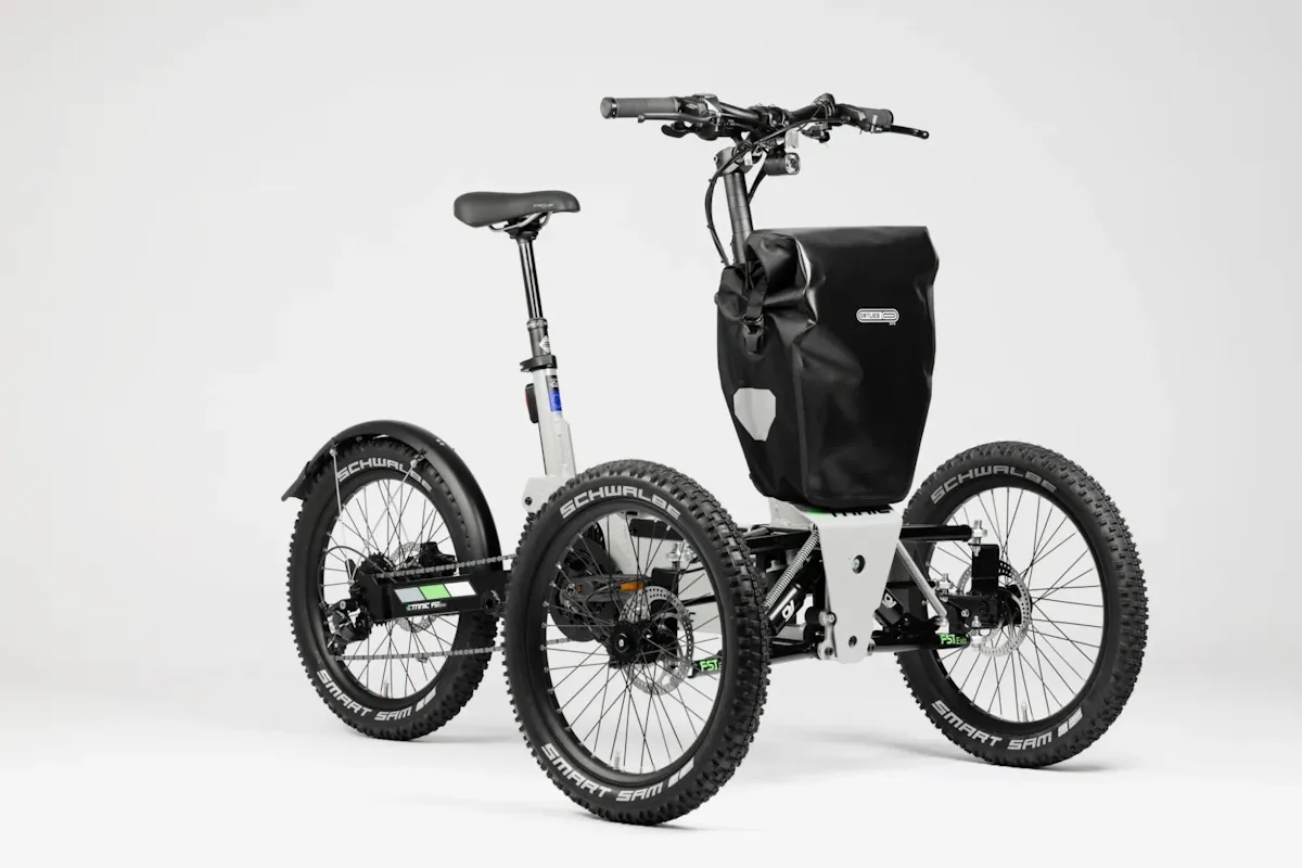 White rugged full suspension e-tricycle with off road tyres and a front cargo bag